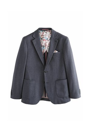 Grå blazer i texturerad tyg, med ett foder med blommönster, två framfickor och en bröstficka med en vikt näsduk.