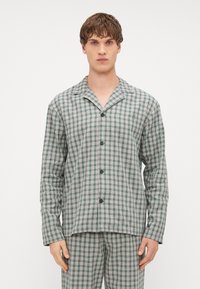Conjunto de pijama a cuadros verdes y grises que incluye una camisa abotonada con cuello de solapa y pantalones a juego con cintura elástica.