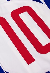 Witte sporttrui met een opvallend rood nummer "10", met blauwe accenten en een textuurstof. Het ontwerp heeft twee rode strepen.