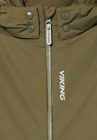 Olive krāsas ūdensnecaurlaidīgs jaka ar rāvējslēdzēju priekšpusē, sudraba rāvējslēdzēja detaļām un logotipa apdari. Iekļautas pogu aizdares apkaklē.