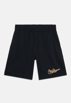 Zwarte sportshorts met elastische tailleband, zijzakken en een gouden Nike-logo op het linkerbeen tegen een witte achtergrond.
