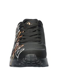 Zapatilla negra con diseños abstractos en naranja y blanco, que cuenta con un cierre de cordones en la parte delantera, una superficie texturizada y una suela acolchada para mayor soporte.