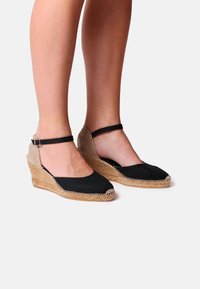 Černé plátěné espadrilky s vázaným juty podešví, se zádovým popruhem a texturovaným tkaným podpatkem, se hladkým designem špičky.