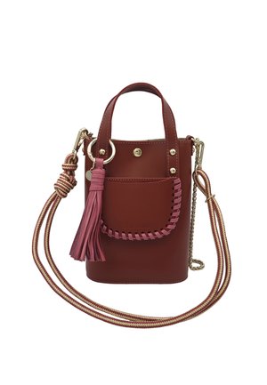 Petit sac bandoulière en cuir bordeaux avec un pompon rose, une poche avant avec un détail tissé rose, une quincaillerie dorée et une bandoulière rayée réglable.
