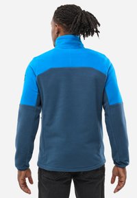 Fleece jacket with a high collar, featuring blue and dark blue panels, textured fabric, and a full range of motion through sleeves.