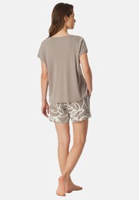 Gray short-sleeve top paired with patterned beige shorts featuring white abstract shapes, made from soft, lightweight fabric.