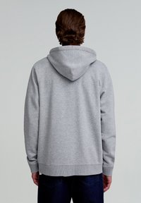 Grau Sweatshirt mit Kapuze und lockerer Passform, gerippten Bündchen und Saum, weicher Textur und einem schlichten Design, von hinten betrachtet.