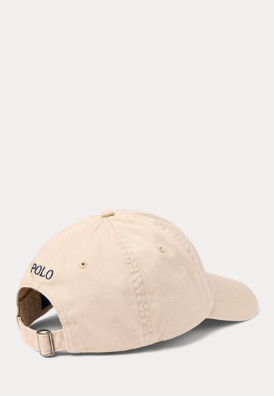 Beige adjustable baseball cap with metal buckle strap and "POLO" embroidered in black on the back side.