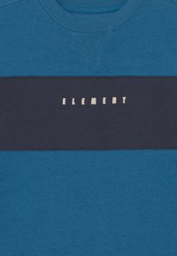 Sudadera azul de cuello redondo con una franja horizontal azul marino y la palabra "ELEMENT" en letras crema. Tejido suave con un detalle texturizado en el cuello.