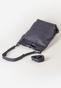 Borsa a tracolla in pelle viola con tracolla regolabile, texture liscia, design minimalista e punti di attacco multipli per versatilità.