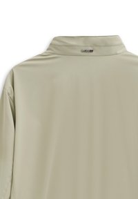 Light gray, smooth fabric shirt with a stand collar and subtle sheen. Features a small brand tag at the back neck.