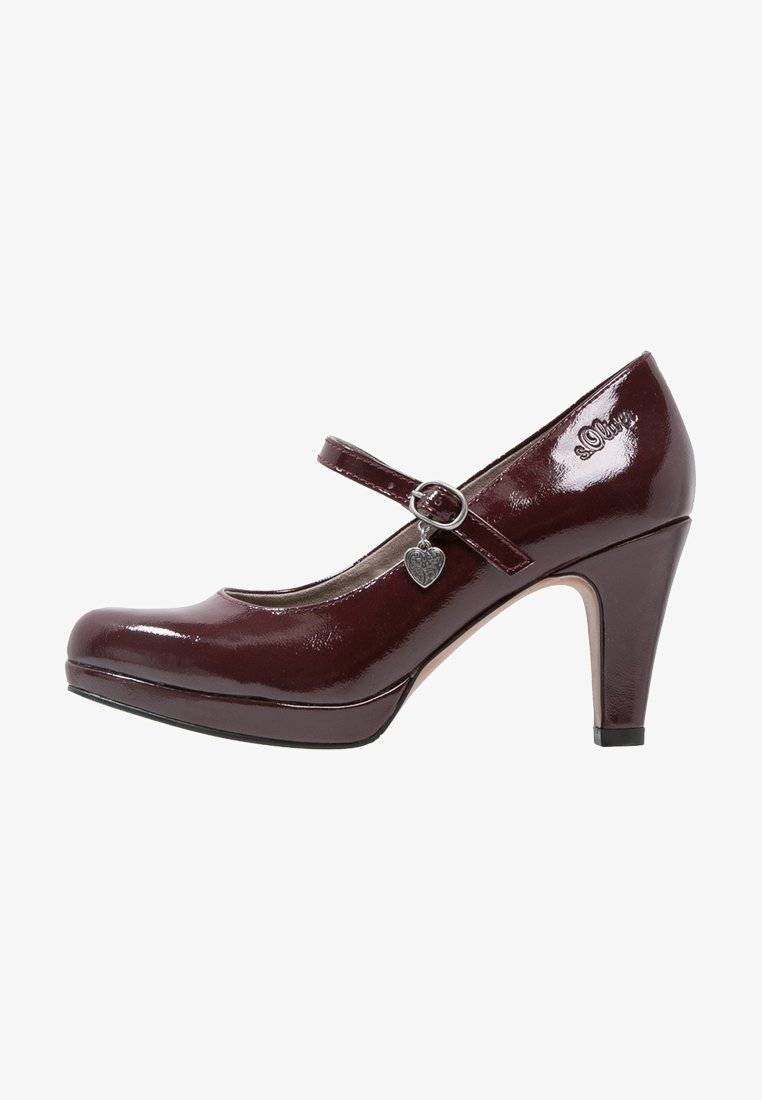 Chaussure Mary Jane à talon haut rouge foncé brillant avec une bride et un petit pendentif en forme de cœur sur fond blanc.