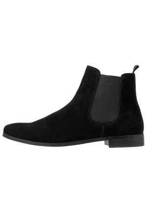 Black suede Chelsea boot with elastic side panel, low heel, and pull tab at the back.