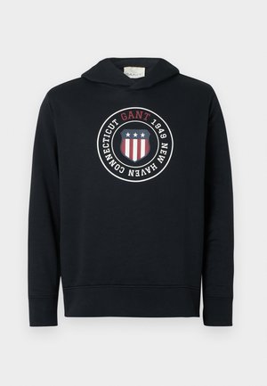 Dunkelblaues Hoodie aus Baumwolle mit einem großen, runden Logografik. Verfügt über eine Kapuze, lange Ärmel und gerippte Manschetten und Saum.