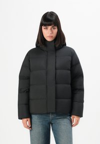Black puffer jacket with a high collar and hood, featuring a quilted design with horizontal seams. Material appears smooth and slightly shiny.