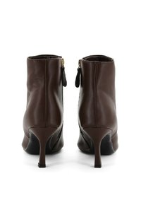 Stivali ankle in pelle marrone con tacco alto, caratterizzati da una cerniera laterale e una superficie testurizzata. Il design è dotato di una silhouette slanciata.