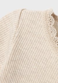 Ribbed beige fabric with delicate lace trim along the neckline. The texture appears soft and lightweight, suitable for casual wear.