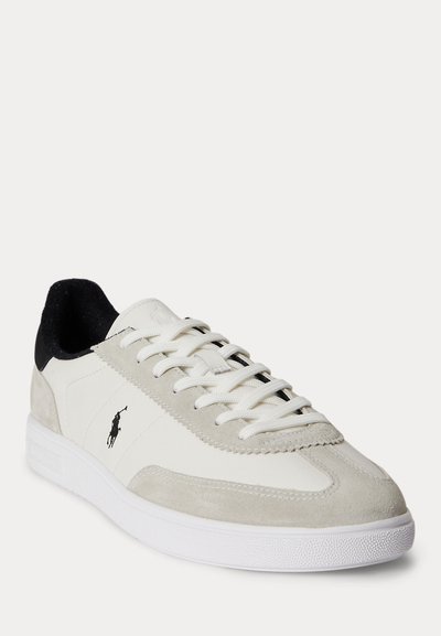 Λευκό και μπεζ παπούτσι χαμηλού προφίλ με κορδόνια μπροστά, μαύρο γιακά και μαύρο λογότυπο Polo Ralph Lauren στο πλάι.