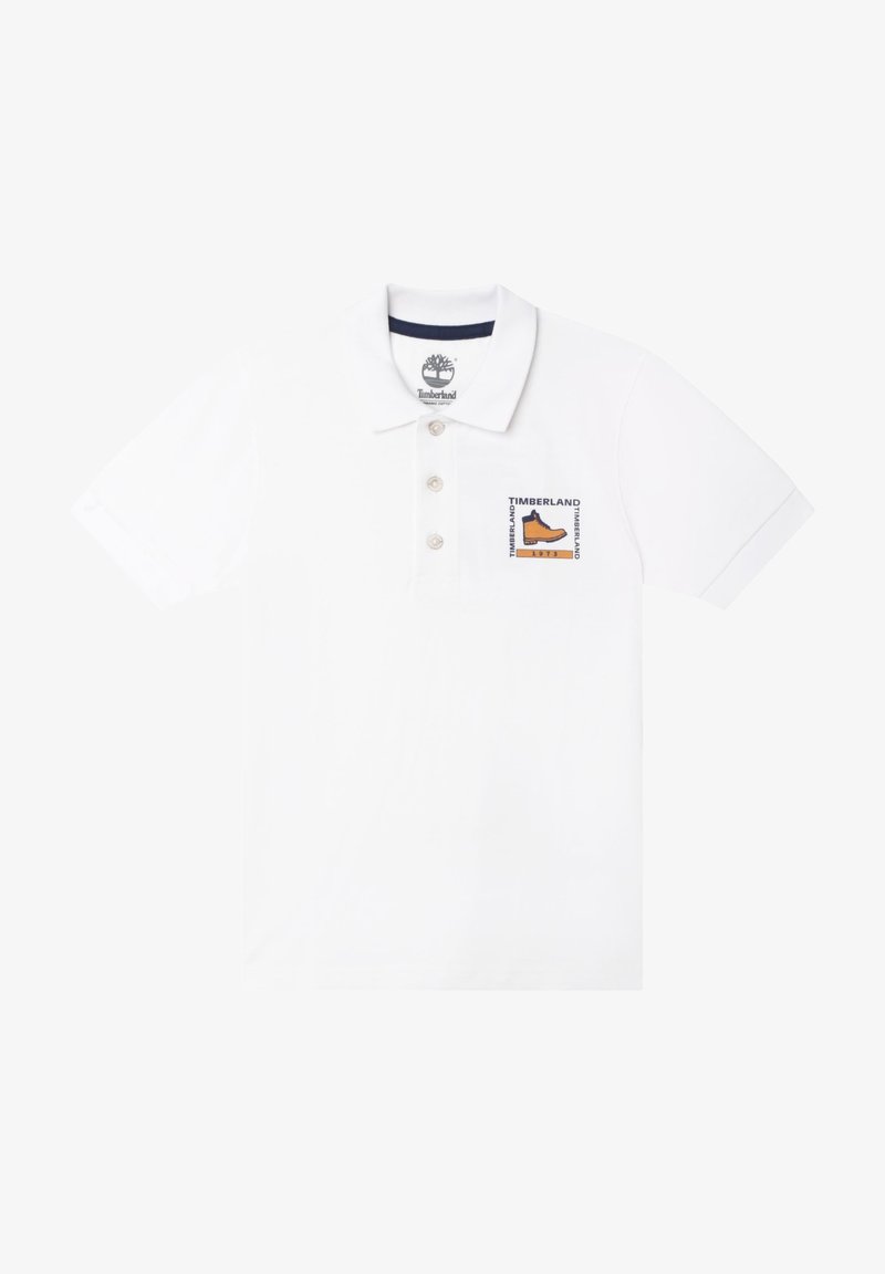 Polo blanc à manches courtes avec trois boutons et écusson du logo Timberland présentant une botte sur le côté gauche de la poitrine.