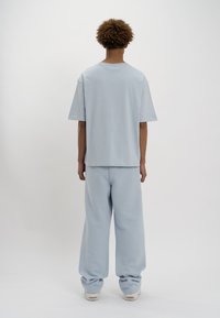 LOW LIGHTS STUDIOS® BASIC LOGO JOGGER - Pantalones deportivos - sky blue