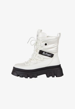 Białe, wyściełane botki za kostkę z czarną gumową podeszwą, sznurowanym przodem i czarną wstążką z logo "Lee Cooper". Teksturowane akcenty z materiału dodają szczegółów.