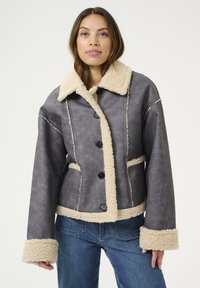 Grijs faux scheerwoljack met een beige kraag en manchetten, voorzien van een knopenfront en zijzakken. Zachte textuur, cropped ontwerp.