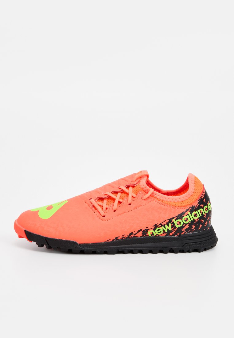 Helle orange Sport-Schuh mit einem synthetischen Obermaterial, schwarzer strukturierter Sohle und grüner "New Balance"-Markierung an der Seite. Schnürdesign.