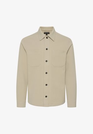 Bēšas krāsas pogājamā krekla izgatavots no mīksta auduma, ar divām krūšu kabatām, melnām pogām un garām piedurknēm ar pogājamiem aproces galiem.