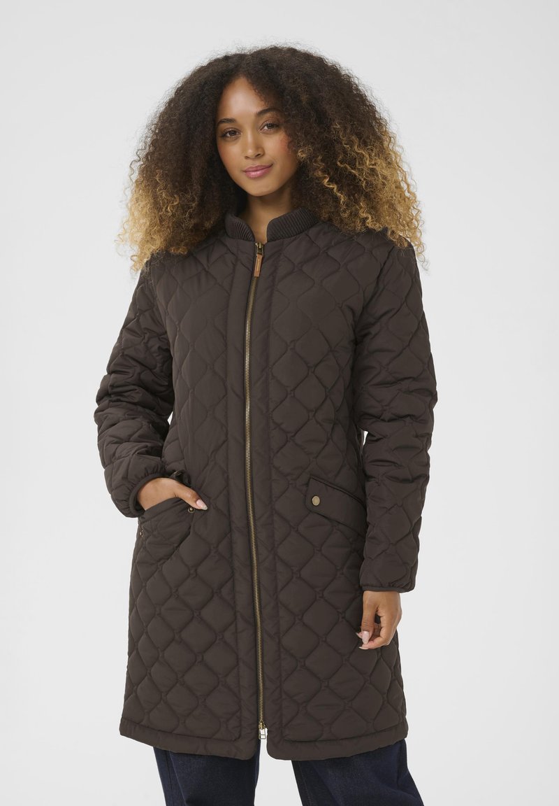 Manteau long matelassé marron avec une fermeture éclair dorée, un col côtelé et des poches latérales. Présente un motif en diamant et une texture lisse.