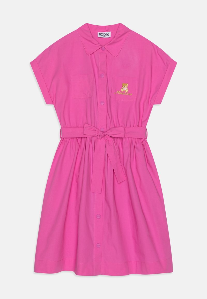 Robe courte rose à manches courtes avec fermeture boutonnée sur le devant, deux poches poitrine, taille ceinturée et motif d'ours brodé sur la poche de gauche.