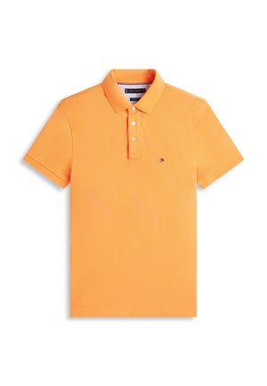 Polo arancione a maniche corte con tre bottoni bianchi e piccolo logo Tommy Hilfiger sul petto sinistro, distesa su sfondo bianco.