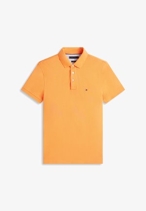 Orangefarbenes kurzärmeliges Poloshirt mit drei weißen Knöpfen und kleinem Tommy Hilfiger-Logo auf der linken Brust, flach auf weißem Hintergrund liegend.