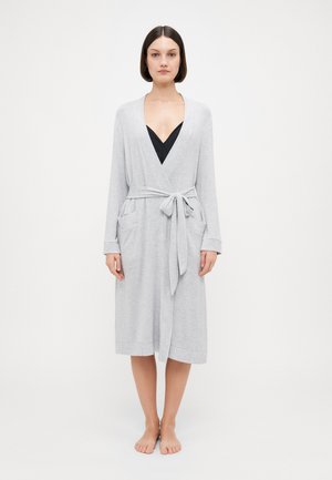 Robe gris clair à manches longues avec une ceinture, deux poches latérales et un décolleté en V. Texture douce, longueur jusqu'au genou et poignets côtelés.