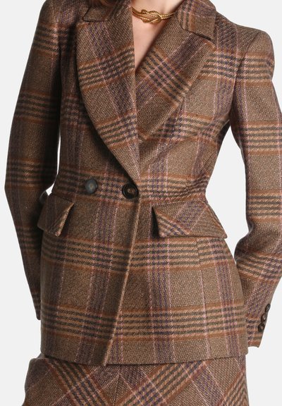 Blazer tailleur à carreaux marron et violet avec larges revers, fermeture double bouton, poches à rabat et jupe assortie à carreaux.