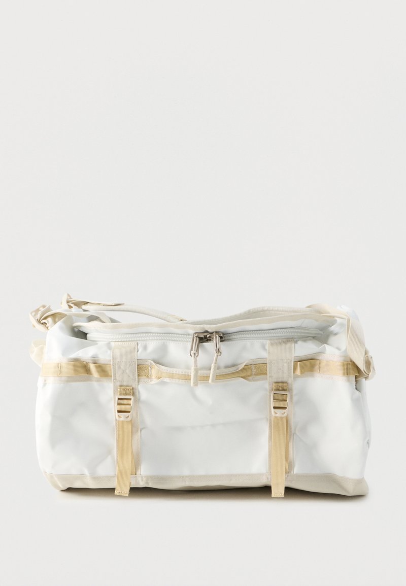 Λευκή ορθογώνια τσάντα duffel με μπεζ ιμάντες, δύο αγκράφες, φερμουάρ με δύο τράβηγμα και ρυθμιζόμενο ιμάντα ώμου.