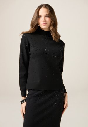 Czarny sweter z dzianiny z wysokim dekoltem, z teksturowanym wzorem z małymi błyszczącymi akcentami rozsianymi po całej powierzchni. Miękka tkanina w dopasowanym kroju.
