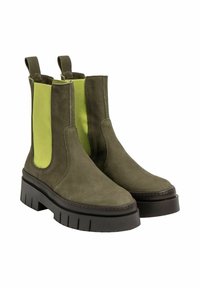 Botas de tobillo verde olivo con paneles laterales elásticos verde lima, suelas de plataforma negra gruesas y puntas redondeadas, con una textura de cuero suave.