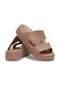 Braune Plattformsandalen mit offener Zehenpartie und Ausstanzungen. Hergestellt aus glattem Material mit abgerundetem Absatz und Markenlogo.