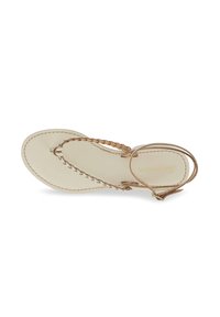 Leather thong sandal in light beige with braided straps, flat sole, and ankle strap. Notable stitching along the edge. Brand logo embossed.