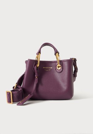 Tiefviolette Lederhandtasche mit goldfarbenen Beschlägen, zwei Tragegriffen, verstellbarem Schulterriemen und kleinem goldfarbenem Emporio Armani Logo vorne.