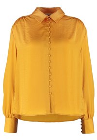 Žlutá saténová halenka s límečkem, zapínáním na knoflíky vpředu a dlouhými rukávy. Má knoflíky na manžetách a mírně zaoblený lem. Hladká textura.