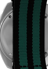 Bracelet noir avec des bandes texturées vertes, base métallique argentée, et vis visibles. Présente un motif tissé pour une meilleure prise et durabilité.