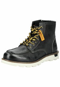 Botín negro de cuero con cordones amarillos y negros estampados, suela de goma blanca y detalles de costura. Etiqueta de logo cerca de los cordones.