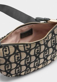Pruun ja mustad mustrid omav käekott, millel on tõmblukk, sile sisemus ja kuldne riistvara. Includes a black strap.