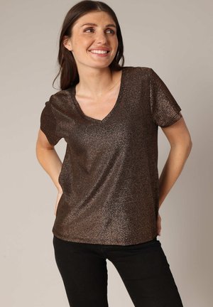 Bronzen V-hals T-shirt met korte mouwen; glanzende, gestructureerde stof; aansluitend ontwerp; gedragen met zwarte broek; subtiele glans.