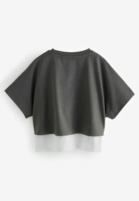 Afklippet grå bomulds T-shirt med korte ærmer. Har et gennemsigtigt hvidt lag i kanten. Enkel, afslappet design med rund hals.