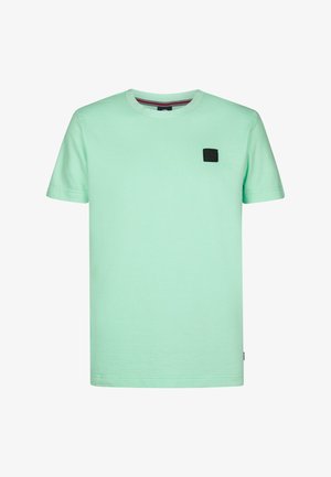 T-shirt en coton vert menthe à manches courtes, col rond, avec une petite étiquette noire sur la poitrine. Texture douce et design simple.
