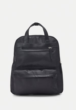 Sac à dos en nylon noir avec deux poches avant zippées, des poignées supérieures doubles et une texture lisse. Présente une forme structurée et un design minimaliste.