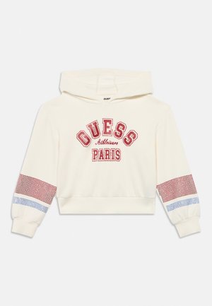 Kremasti hoodie s crvenim tekstom "GUESS Athleisure PARIS" i crvenim i plavim karo prugama na rukavima.