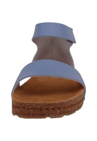 Sandalia de imitación de cuero azul claro con una cinta ancha en la puntera y una correílla en el tobillo, que presenta una suela de corcho marrón, altura plana y textura suave.